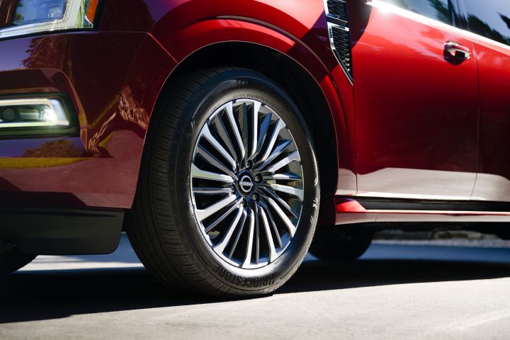 Close up of the front left wheel on a red 2025 Nissan Armada.