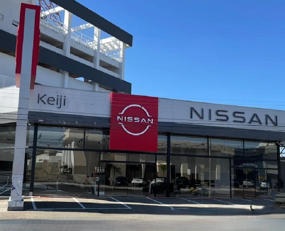 Fachada da nova concessionária Nissan em Uberaba, com design moderno, janelas de vidro, logo da Nissan em destaque e carros visíveis no interior