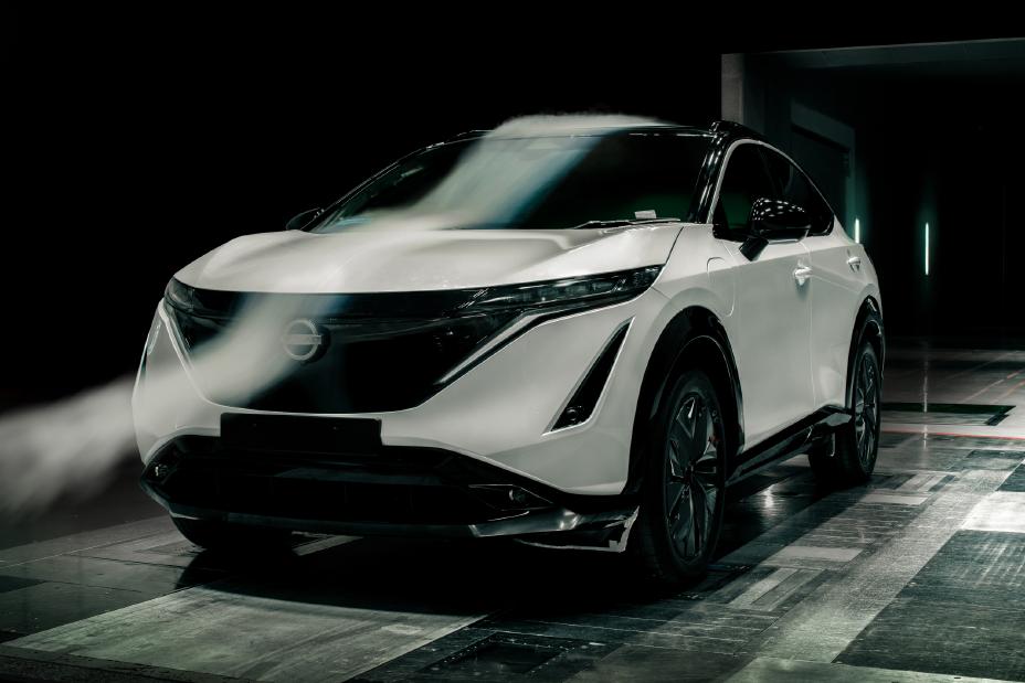 A white Nissan ARIYA in a dark room.