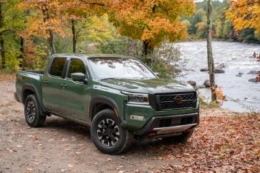 Front passenger side view of a parked green 2022 Nissan Frontier.