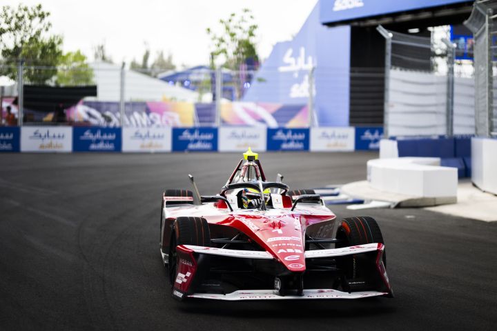 Frontalaufnahme von Oliver Rowland im Nissan Formel E Rennwagen mit der Startnummer 1, wie er aus einer Kurve herausfährt und das Lenkrad dreht.