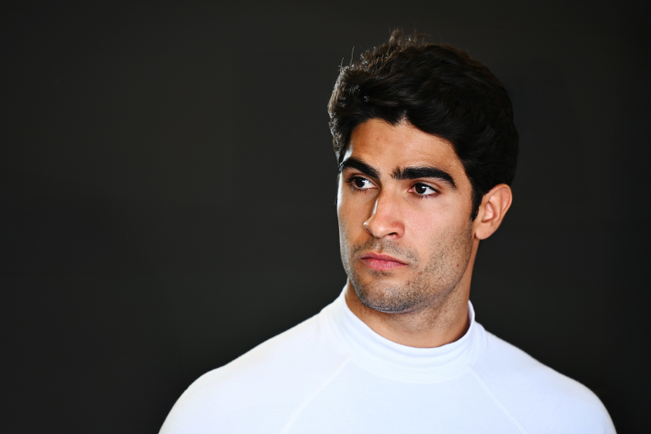 Sérgio Sette Câmara with a white undershirt on with a black background.