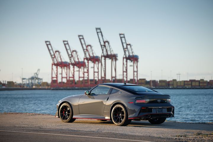 Rear angled view of the 2027 Nissan Z NISMO MT parked in front of a body of water.