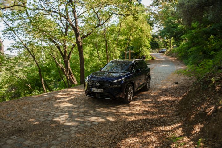 Dreiviertelansicht auf den Nissan X‑Trail, der durchs grüne fährt