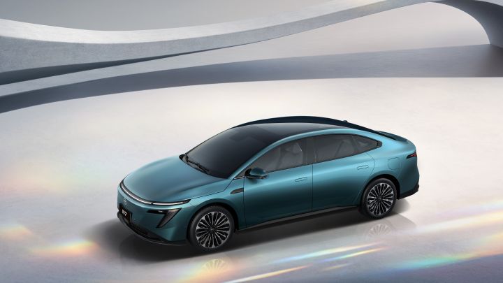 A high front three quarter view of a green Dongfeng Nissan N7 electric sedan against abstract white background
