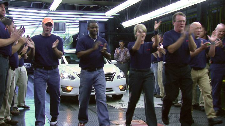 people clapping in front of the 2013 Nissan Altima