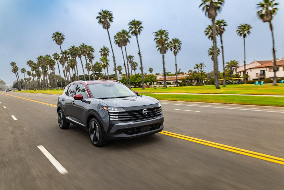 Front right 3/4 angle of a 2026 Nissan Kicks driving along a palm tree lined road.