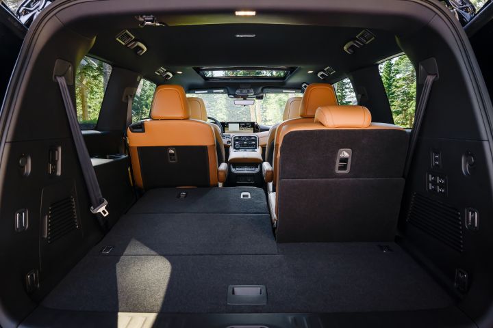 View of the interior from the open hatch back of a 2025 Nissan Armada, the cargo space and one third row seat can be seen.