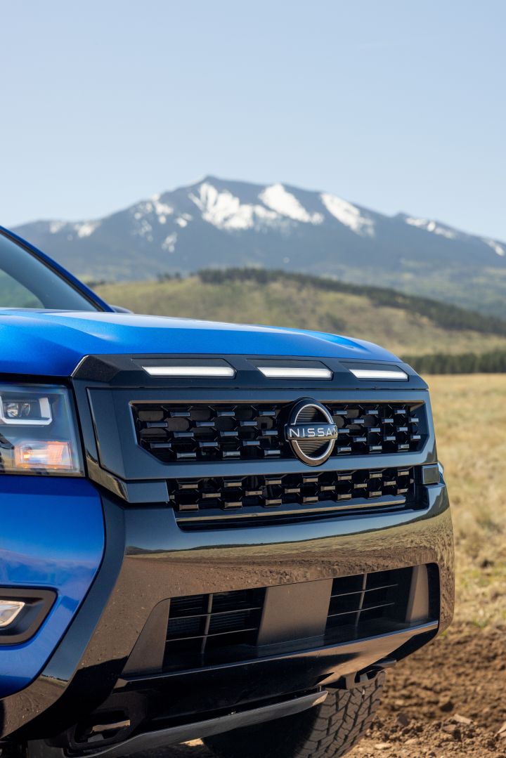 Close up of the front end of the 2027 Nissan Frontier Sport Edition with mountains behind.