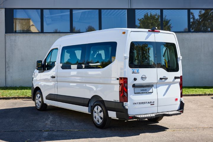 3/4 Heckansicht eines weißen Nissan Interstar-e mit MobiTEC Ausbau, der vor einem grauen Gebäude parkt