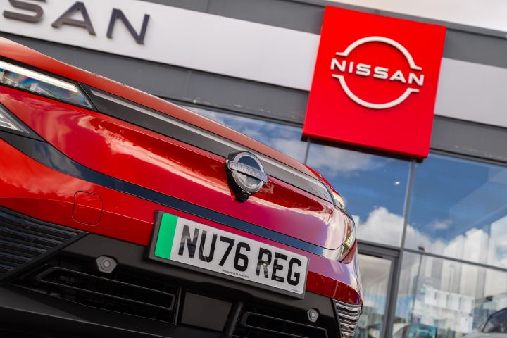 Close-up of the front of a red Nissan LEAF outside a Nissan dealership