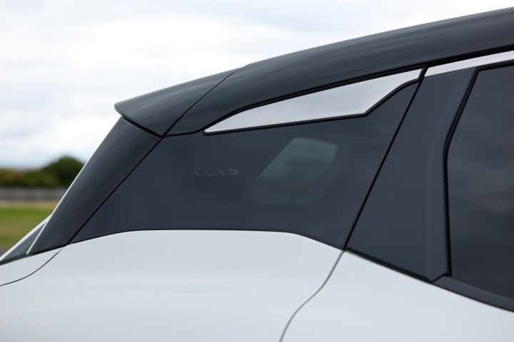 白系キックスのルーフまわりのクローズアップ。ブラックルーフとリアスポイラーが強調され、車両は右向きに配置されている。背景は曇り空。
