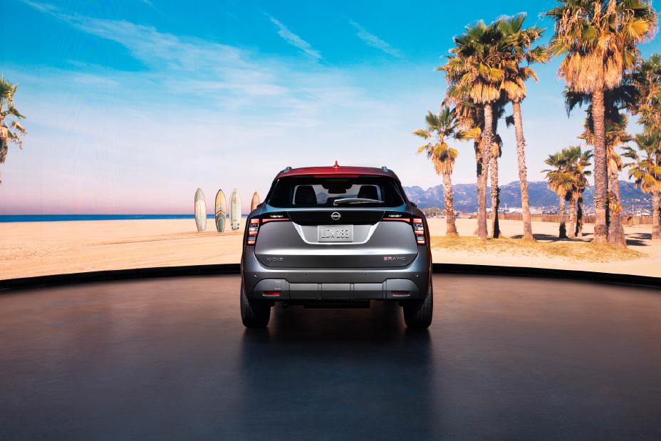 Rear view of the 2025 Nissan Kicks parked against a tropical background with palm trees and ocean water.