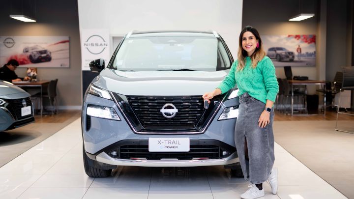 Deportista Francisca Crovetto junto a un Nissan X‑Trail e‑Power estacionado en la concesionaria