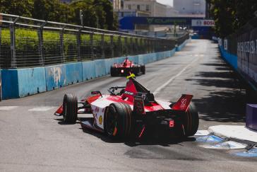 Rear view of a Nissan Formula E race car rounding a corner.