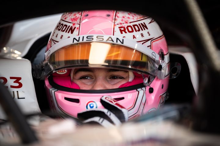 Abbi Pulling mit Helm im Auto in der Garage des Nissan Formula E Teams