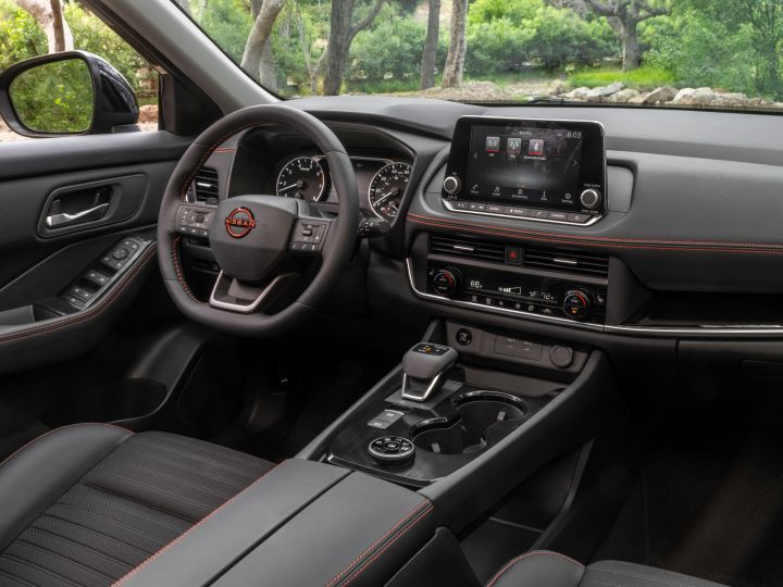 The steering wheel and driver controls inside the 2025 Nissan Rogue rock creek viewed from the passenger side.