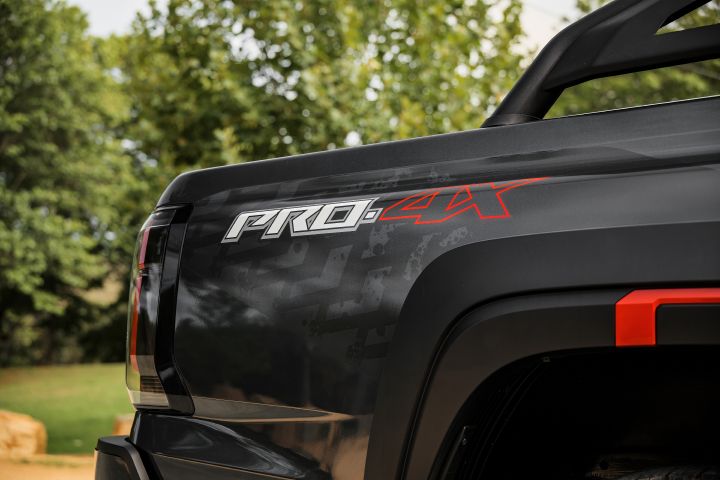 2026 Nissan Navara PRO-4X finished in Boulder Grey showing the rear quarter with PRO-4X decal, tail-light edge and red-accented fender flare.