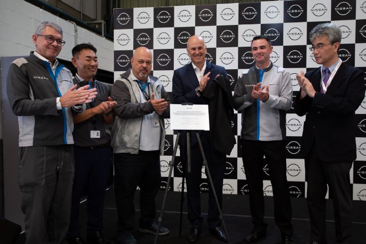 Pessoas mostram a placa que marca a inauguração do Centro Integrado de Engenharia e Qualidade da Nissan do Brasil