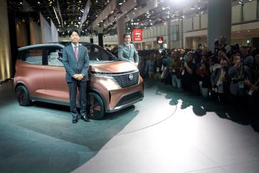 Two men posing on stage with the IMk concept vehicle