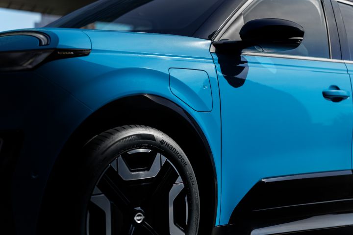Detailaufnahme einer Seite eines blauen Nissan Micra mit Fokus auf die Ladeklappe
