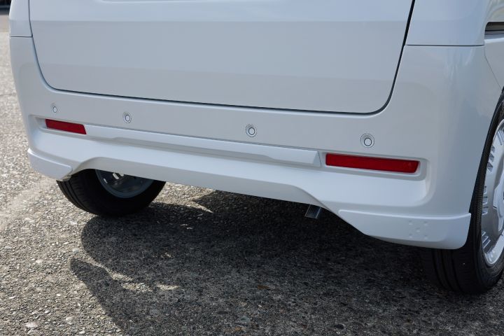 The white body of the new Nissan Roox kei car is equipped with a rear bumper finisher. Shadows cast on the ground enhance the sharp and refined look of the rear design.