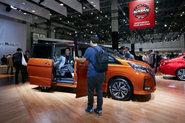 Les participants au Salon automobile de Tokyo 2019 regardent et s'assoient dans un véhicule Nissan