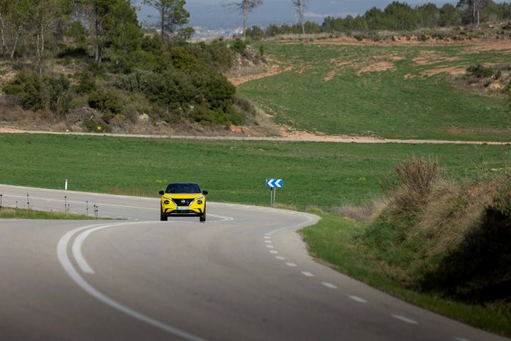 coche Juke amarillo de lejos en un paisaje verde