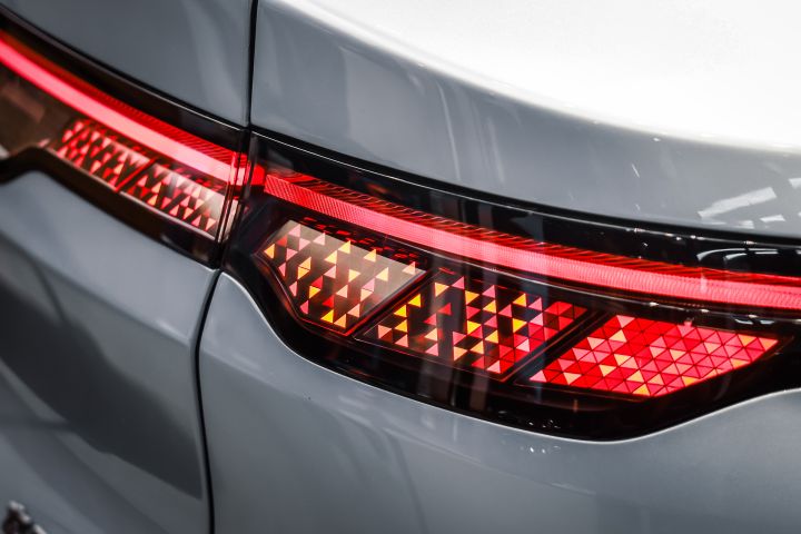東風日産の白い新型セダン電気自動車「N7」のテールランプのクローズアップ。赤とオレンジのダイヤモンドパターンが点灯。