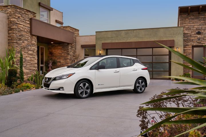 A white Nissan LEAF parked in a driveway