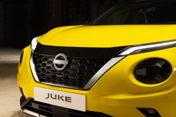 Gelber Nissan Juke auf hellem Untergrund vor dunklem Hintergrund, Detail, Front