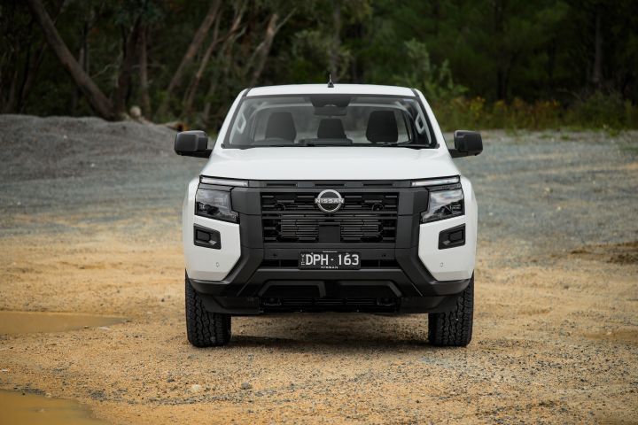 2026 Nissan Navara SL dual cab ute finished in Alpine White shown from the front, highlighting the grille design, Nissan badge placement and symmetrical headlight arrangement.