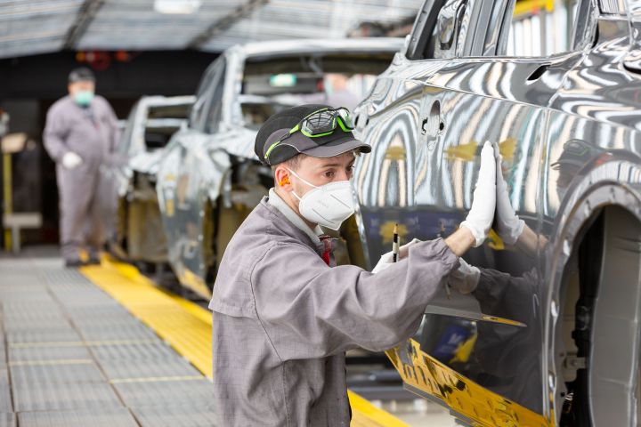 A worker at Nissan Sunderland Plant inspecting the exterior of a Qashqai e‑POWER model.