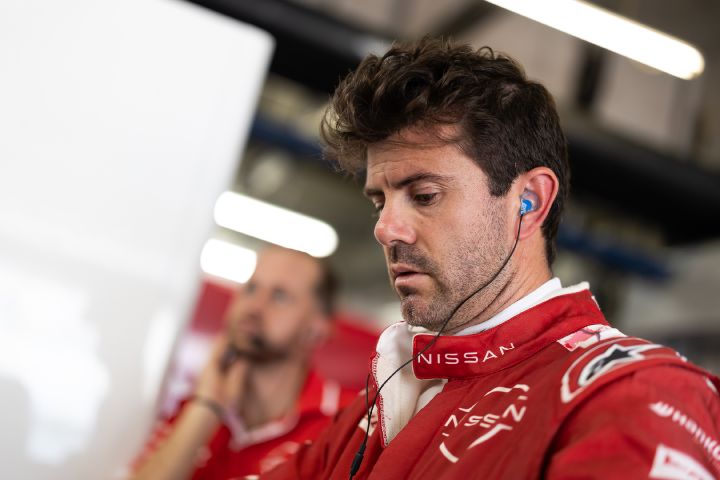 Norman Nato in der Nissan Box, er trägt seinen roten Rennanzug und Ohrhörer.