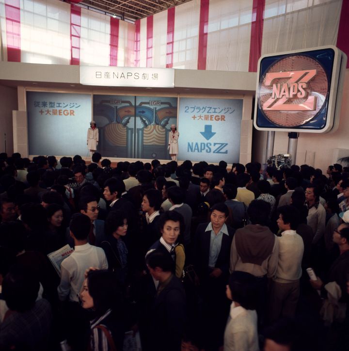 a large crowd of people waiting in front of a display labeled naps z at the auto show