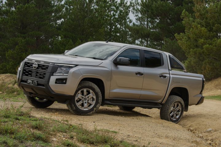2026 Nissan Navara ST dual cab ute finished in Summit Silver shown from the front three-quarter angle parked on a dirt ridge.