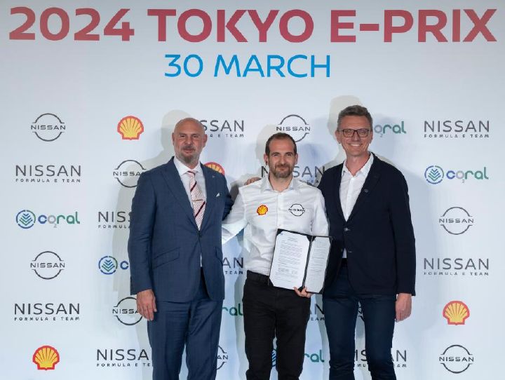 Tommaso Volpe tenant le contrat d’engagement entouré de Jeff Dodds (à gauche) et Marek Nawarecki à droite devant un fond avec les logos Nissan, Formula E Coral et Shell.
