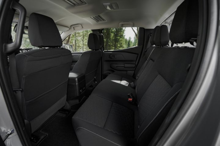 2026 Nissan Navara ST dual cab ute finished in Summit Silver shown from the rear cabin, featuring the cloth bench seat, headrests and rear passenger space.