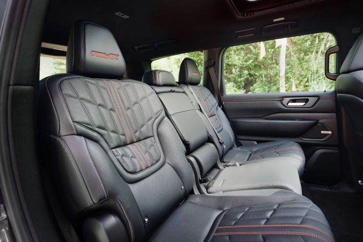 View from the rear passenger door of the second-row black leather and red stitching seats inside the 2025 Nissan Armada.