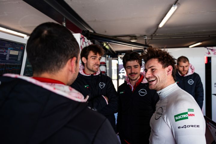 Mehrer Nissan Formel E Teammitglieder stehen während der Rookie Tests in Madrid in der Nissan Teamgarage und unterhalten sich lachend