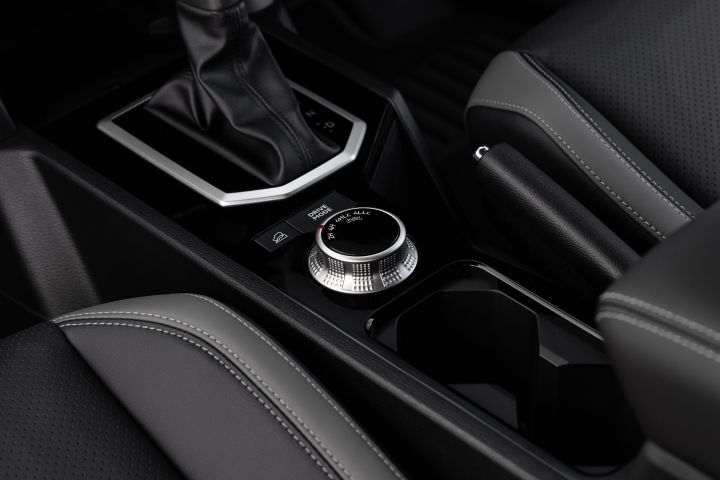 Close-up of the centre console in a 2026 Nissan Navara ST-X, focused on the rotary drive-mode selector beside the automatic gear selector and cupholder.