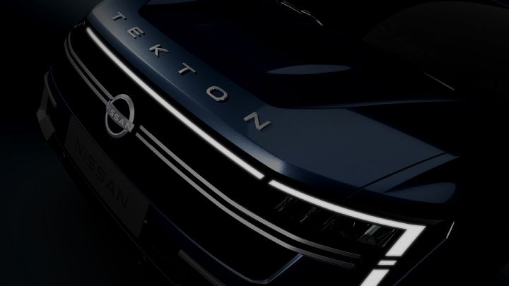 Close-up of the Nissan Tekton’s front hood and grille, featuring illuminated LED headlights and the bold "TEKTON" branding.