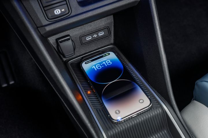 Detailed shot of iPhone charging on the wireless charging pad on the centre console in the new Micra detailed shot of opened glovebox inside the new Micra interior