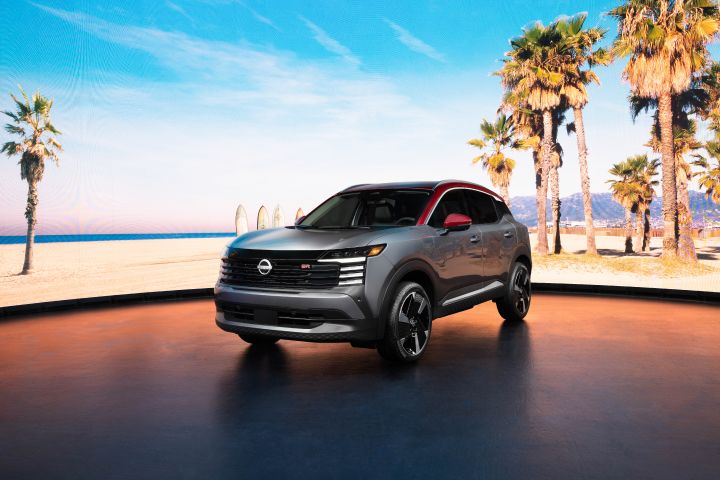 Front left 3/4 of the 2025 Nissan Kicks parked against a tropical background with palm trees and ocean water
