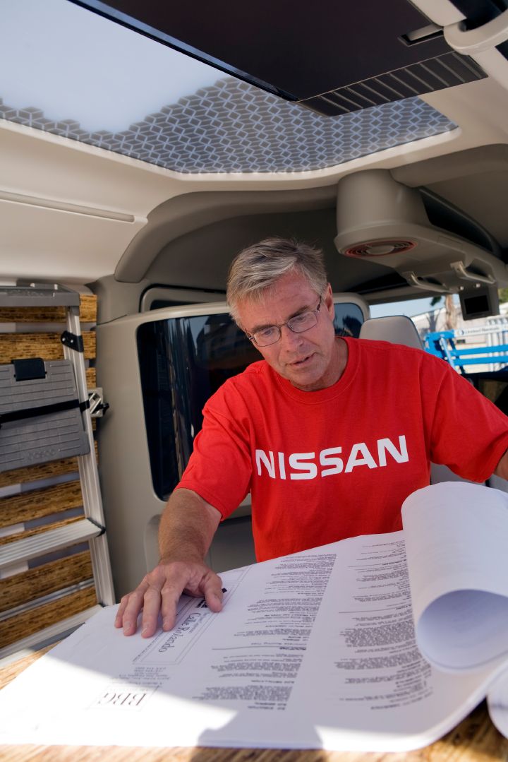 Man reading papers, sitting at the chair inside the NV2500 Concept