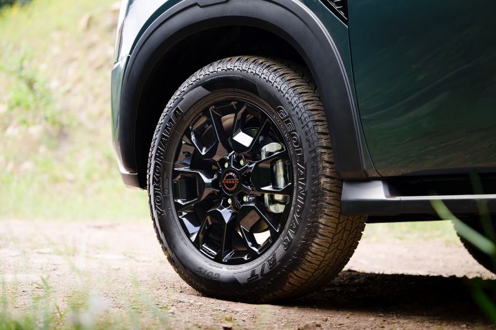 Close up of the front tire and shiny black rim on the 2025 Nissan Armada Pro 4X that is parked on a dirt path.