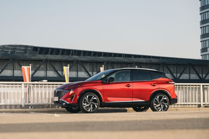 Ein Nissan Qashqai in Fuji Sunset Red parkt auf einem Flughafenparkplatz