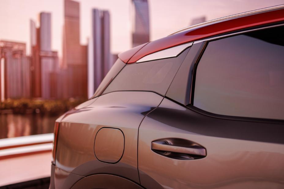 The 2025 Nissan Kicks from the passenger door and back, the two-toned red and silver paint can be seen here.