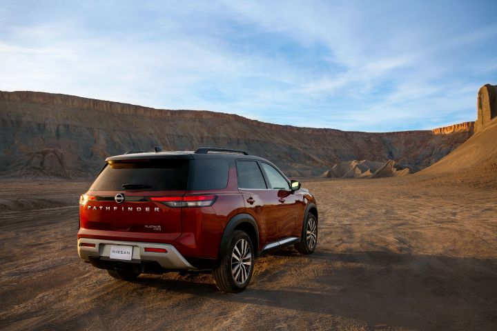 A red Nissan Pathfinder parked in a desert setting