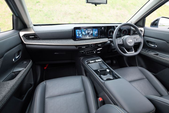 キックスのインテリア全体。右ハンドル仕様の運転席と助手席が見える構図で、ダッシュボード、センターディスプレイ、シートが黒基調で統一されている。